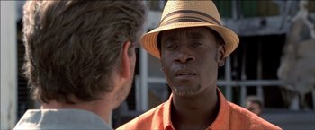 Movie still from “After the Sunset” (2004), directed by Brett Ratner – A man wearing a hat talking to another man; Close Up shot, Over the shoulder angle