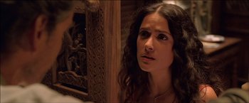 Movie still from “After the Sunset” (2004), directed by Brett Ratner – A beautiful woman with long brown curly hair looking to her left; Close Up shot, Over the shoulder angle