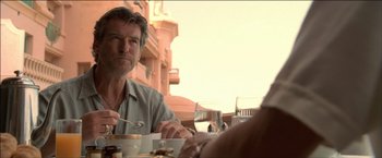 Movie still from “After the Sunset” (2004), directed by Brett Ratner – A man sitting at a table with a plate of food; Close Up shot, Over the shoulder angle