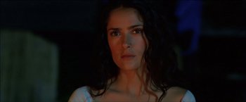 Movie still from “After the Sunset” (2004), directed by Brett Ratner – A woman with long black curly hair stares at the camera; Close Up shot, Over the shoulder angle