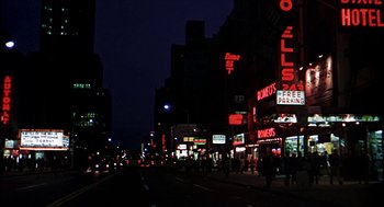 Movie still from “Age of Consent” (1969), directed by Michael Powell – A city street at night lit up by street lights; Extreme Wide shot, High angle