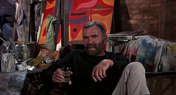 Movie still from “Age of Consent” (1969), directed by Michael Powell – An older man holding a glass of alcohol; Medium shot, Low angle