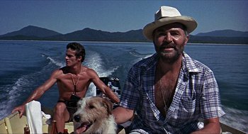 Movie still from “Age of Consent” (1969), directed by Michael Powell – Two men and a dog on a boat in the water; Medium shot, Low angle