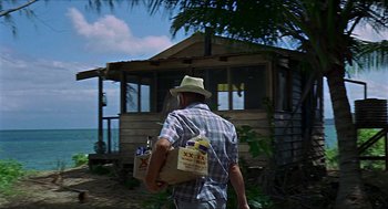 Movie still from “Age of Consent” (1969), directed by Michael Powell – A man walking with a bag of food in his hand; Wide shot, Low angle