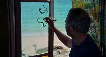 Movie still from “Age of Consent” (1969), directed by Michael Powell – A man is painting on a window by the beach; Close Up shot, High angle