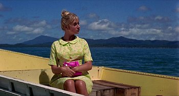 Movie still from “Age of Consent” (1969), directed by Michael Powell – A woman sitting in a boat on the water; Medium shot, Low angle