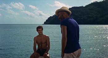Movie still from “Age of Consent” (1969), directed by Michael Powell – Two men standing on the shore of a body of water; Medium shot, Over the shoulder angle