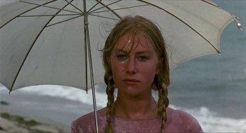 Movie still from “Age of Consent” (1969), directed by Michael Powell – A young woman holding an umbrella while standing in the rain; Close Up shot, Low angle