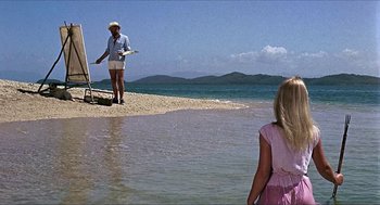 Movie still from “Age of Consent” (1969), directed by Michael Powell – A woman standing on the beach with a child; Wide shot, Over the shoulder angle