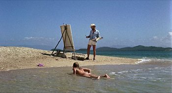 Movie still from “Age of Consent” (1969), directed by Michael Powell – A man standing next to a body of water; Wide shot, Low angle