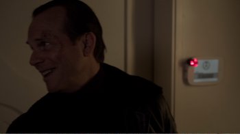Movie still from “Agents of S.H.I.E.L.D.” (2013), created by Joss Whedon – A man in a leather jacket is smiling; Close Up shot, Over the shoulder angle