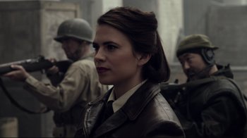 Movie still from “Agents of S.H.I.E.L.D.” (2013), created by Joss Whedon – A woman wearing a leather jacket and a hat; Close Up shot, Over the shoulder angle