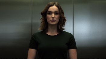 Movie still from “Agents of S.H.I.E.L.D.” (2013), created by Joss Whedon – A woman in a black t - shirt in an elevator; Close Up shot, Low angle