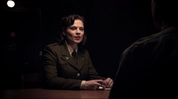 Movie still from “Agents of S.H.I.E.L.D.” (2013), created by Joss Whedon – A woman sitting at a table in front of a man; Medium shot, Over the shoulder angle