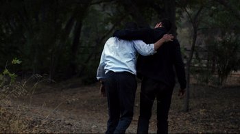 Movie still from “Agents of S.H.I.E.L.D.” (2013), created by Joss Whedon – Two men are hugging in the woods; Medium shot, Over the shoulder angle