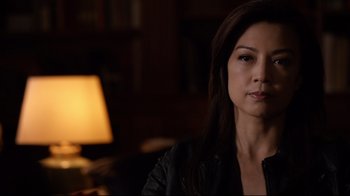 Movie still from “Agents of S.H.I.E.L.D.” (2013), created by Joss Whedon – A person sitting in a room near a lamp; Close Up shot, Over the shoulder angle