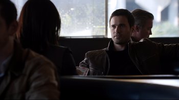Movie still from “Agents of S.H.I.E.L.D.” (2013), created by Joss Whedon – A man sitting at a table in front of two other people; Medium shot, Over the shoulder angle