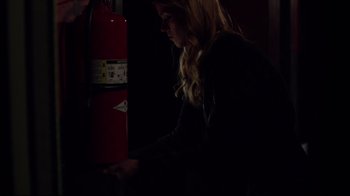 Movie still from “Agents of S.H.I.E.L.D.” (2013), created by Joss Whedon – A woman in a dark room looking at a fire hydrant; Medium shot, High angle