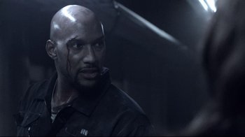 Movie still from “Agents of S.H.I.E.L.D.” (2013), created by Joss Whedon – A man with blood on his face is looking at the camera; Close Up shot, Over the shoulder angle