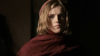Movie still from “Game of Thrones” (2011), created by D.B. Weiss – A woman with long blonde hair wearing a red robe; Close Up shot, Low angle
