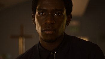 Movie still from “Snowfall” (2017), directed by Hiro Murai – A man's face in a dark room; Close Up shot, Low angle