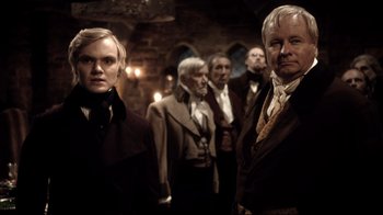 Movie still from “Agents of S.H.I.E.L.D.” (2013), created by Joss Whedon – A group of men standing next to each other in a room; Medium shot, Over the shoulder angle