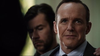 Movie still from “Agents of S.H.I.E.L.D.” (2013), created by Joss Whedon – A man in a suit and tie next to another man in a suit and tie; Close Up shot, Over the shoulder angle