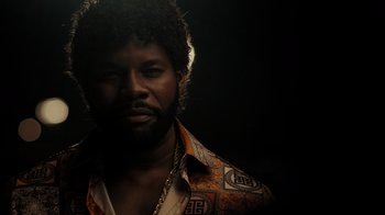 Movie still from “Snowfall” (2017), directed by Hiro Murai – A man with a beard wearing a colorful shirt; Close Up shot, Low angle