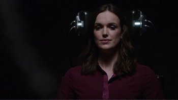Movie still from “Agents of S.H.I.E.L.D.” (2013), created by Joss Whedon – A woman in a purple shirt is in a dark room; Close Up shot, Over the shoulder angle