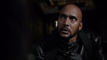 Movie still from “Agents of S.H.I.E.L.D.” (2013), created by Joss Whedon – A bald man in a black leather jacket looking to his left; Close Up shot, Over the shoulder angle