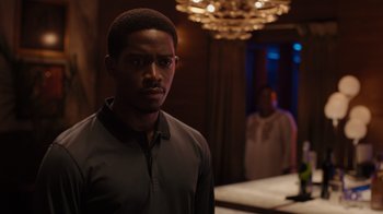 Movie still from “Snowfall” (2017), directed by Hiro Murai – A man standing next to another man in front of a mirror; Medium shot, Over the shoulder angle