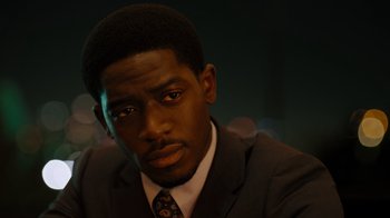 Movie still from “Snowfall” (2017), directed by Hiro Murai – A person wearing a suit and tie; Close Up shot, High angle