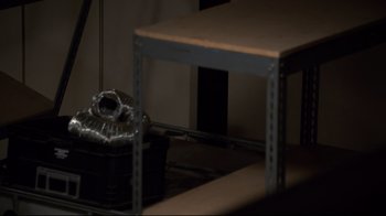 Movie still from “Agents of S.H.I.E.L.D.” (2013), created by Joss Whedon – A table and a basket in a dark room; Medium shot, High angle