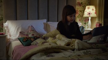Movie still from “Agents of S.H.I.E.L.D.” (2013), created by Joss Whedon – A young girl sitting on a bed looking at her cell phone; Medium shot, High angle