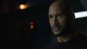 Movie still from “Agents of S.H.I.E.L.D.” (2013), created by Joss Whedon – A man with a bald head looking into the distance; Close Up shot, Over the shoulder angle