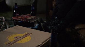 Movie still from “Agents of S.H.I.E.L.D.” (2013), created by Joss Whedon – A person sitting on the floor next to a box of pizza; Medium shot, High angle