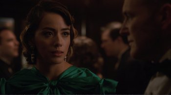 Movie still from “Agents of S.H.I.E.L.D.” (2013), created by Joss Whedon – A woman in a green dress looking at a man in a black suit; Close Up shot, Over the shoulder angle