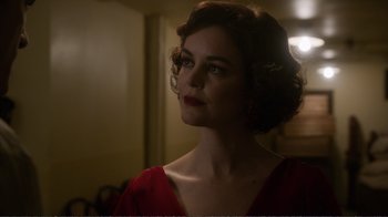 Movie still from “Agents of S.H.I.E.L.D.” (2013), created by Joss Whedon – A woman in a red dress looking to her left; Close Up shot, Over the shoulder angle