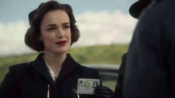 Movie still from “Agents of S.H.I.E.L.D.” (2013), created by Joss Whedon – A woman holding up a driver's license in front of a man; Close Up shot, Over the shoulder angle