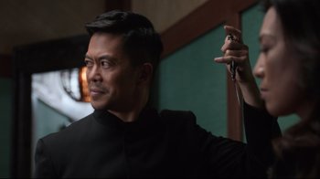 Movie still from “Agents of S.H.I.E.L.D.” (2013), created by Joss Whedon – A man in a black shirt holding a metal object; Close Up shot, Over the shoulder angle