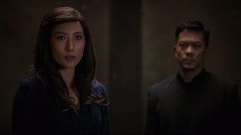 Movie still from “Agents of S.H.I.E.L.D.” (2013), created by Joss Whedon – A man and a woman standing next to each other in front of a wall; Close Up shot, Over the shoulder angle