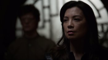 Movie still from “Agents of S.H.I.E.L.D.” (2013), created by Joss Whedon – A woman standing next to a man in front of a building; Close Up shot, Over the shoulder angle