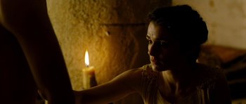 Movie still from “Agora” (2009), directed by Alejandro Amenábar – A woman sitting in front of a lit candle; Close Up shot, Low angle