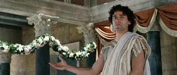 Movie still from “Agora” (2009), directed by Alejandro Amenábar – A man dressed in ancient roman garb holding out his hands; Medium shot, Low angle