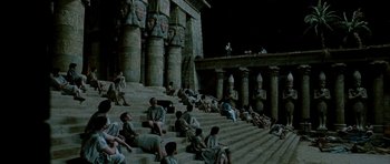 Movie still from “Agora” (2009), directed by Alejandro Amenábar – A group of people sitting on steps in front of a building; Extreme Wide shot, High angle