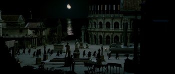 Movie still from “Agora” (2009), directed by Alejandro Amenábar – A group of people standing in front of a building at night; Extreme Wide shot, High angle