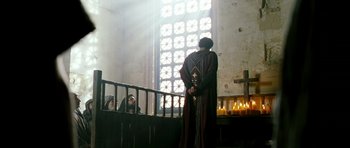 Movie still from “Agora” (2009), directed by Alejandro Amenábar – A man standing in front of a window with candles; Wide shot, Low angle