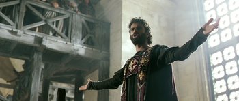 Movie still from “Agora” (2009), directed by Alejandro Amenábar – A man with a beard is standing in front of a building; Medium shot, Low angle