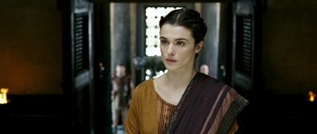 Movie still from “Agora” (2009), directed by Alejandro Amenábar – A woman in a brown and orange dress looking to her left; Close Up shot, Over the shoulder angle