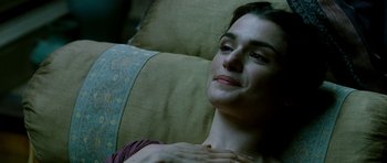 Movie still from “Agora” (2009), directed by Alejandro Amenábar – A woman sitting on top of a couch with her hand on her chest; Close Up shot, High angle